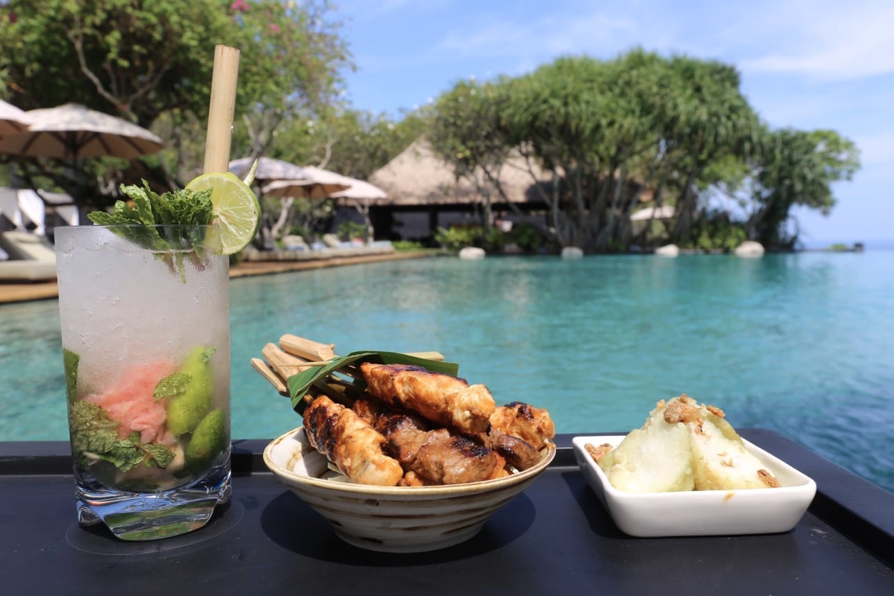 Enjoy a cocktail and Balinese snack by the hotel's infinity pool.