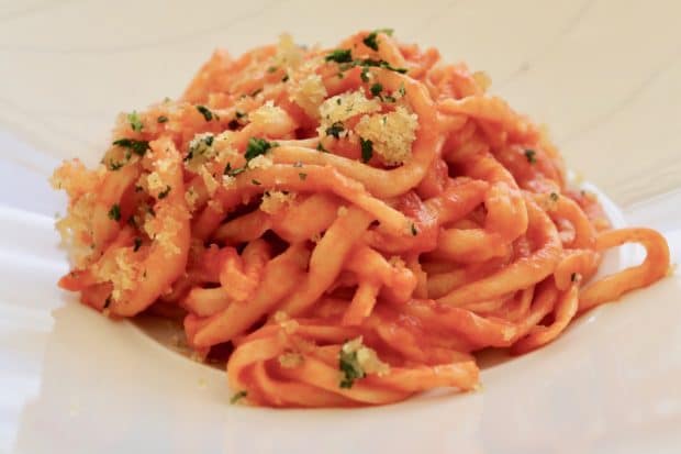 Pici pasta served with tomato sauce and bread crumbs in Tuscany.