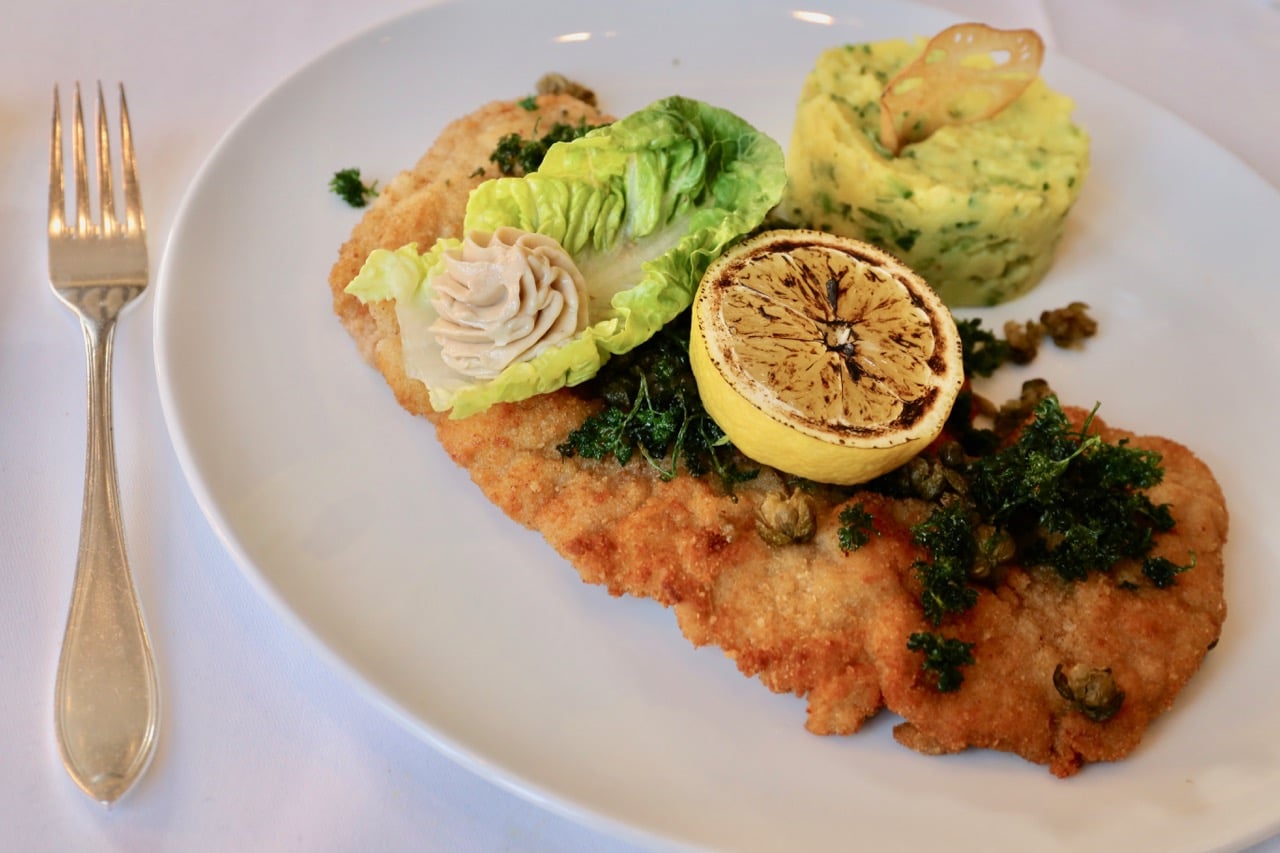 Schnitzel with fried capers, anchovy aioli and grilled lemon.