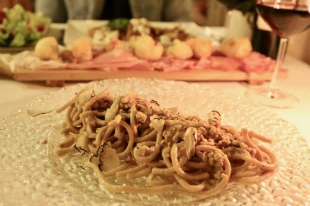 Pici pasta is served with wild boar ragu and black truffles in Pisa.