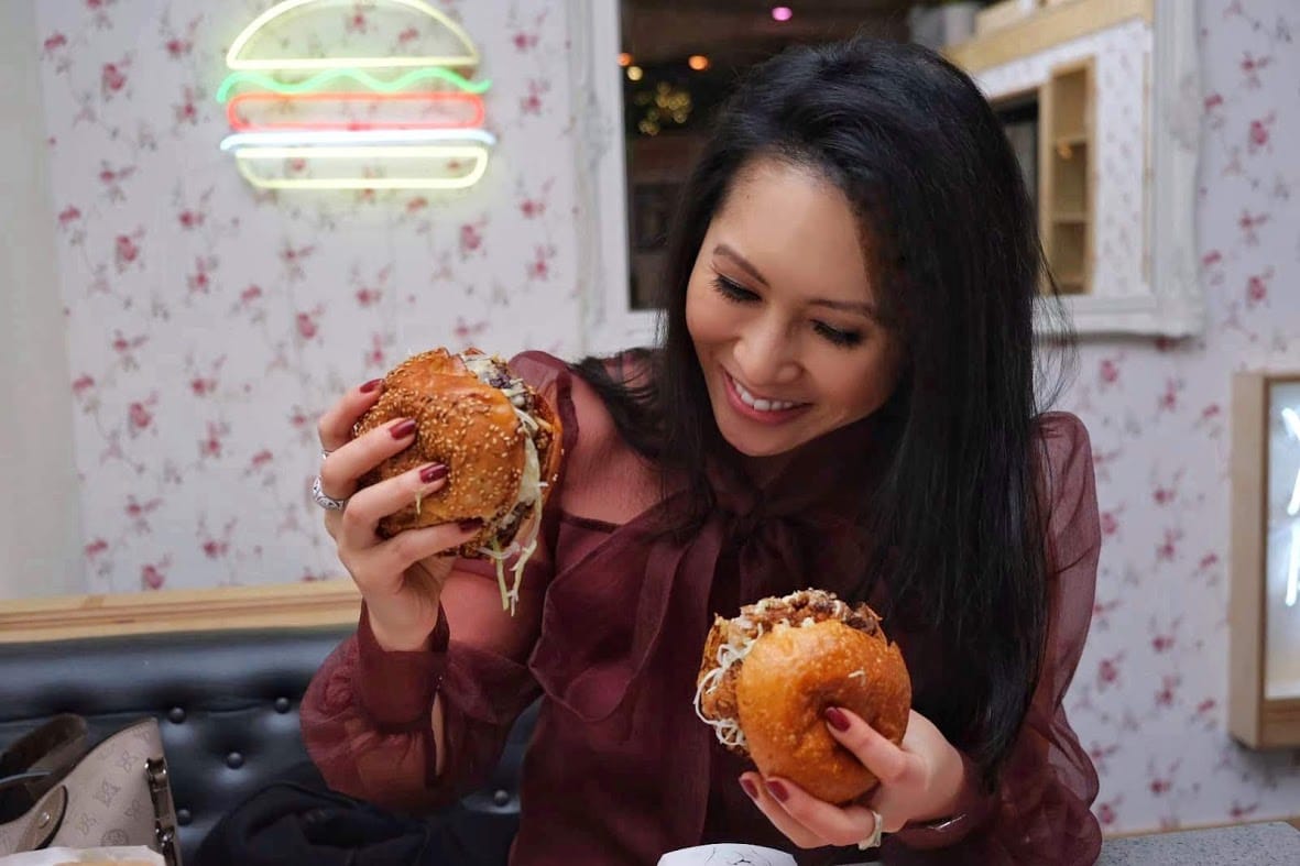 Vancouver food expert Mijiune Pak eats two burgers simultaneously because she's a hero.