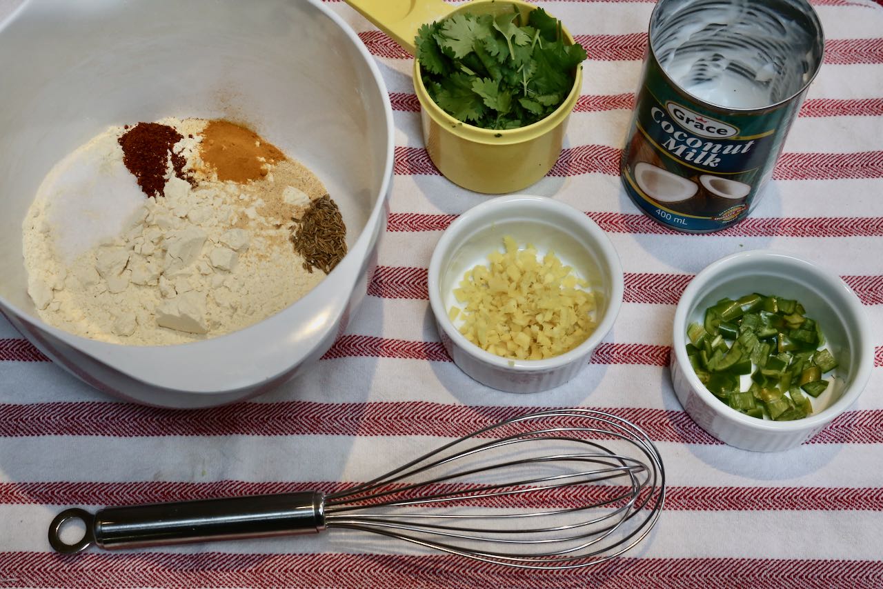 Add dry ingredients into a bowl and measure out the ginger, peppers, cilantro and coconut cream before whisking together.