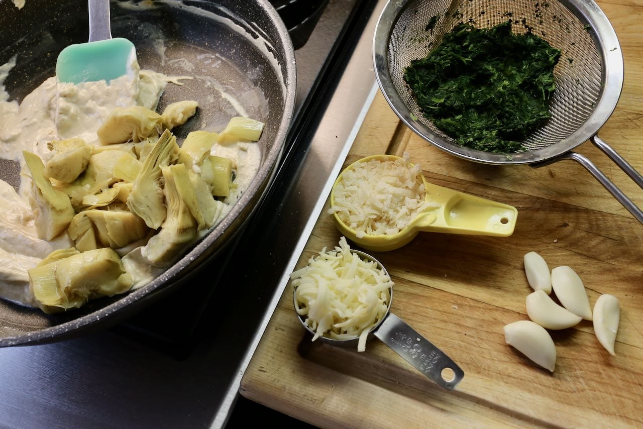 Prepare easy Cheesy Spinach and Artichoke Dip in a pan over the stove.