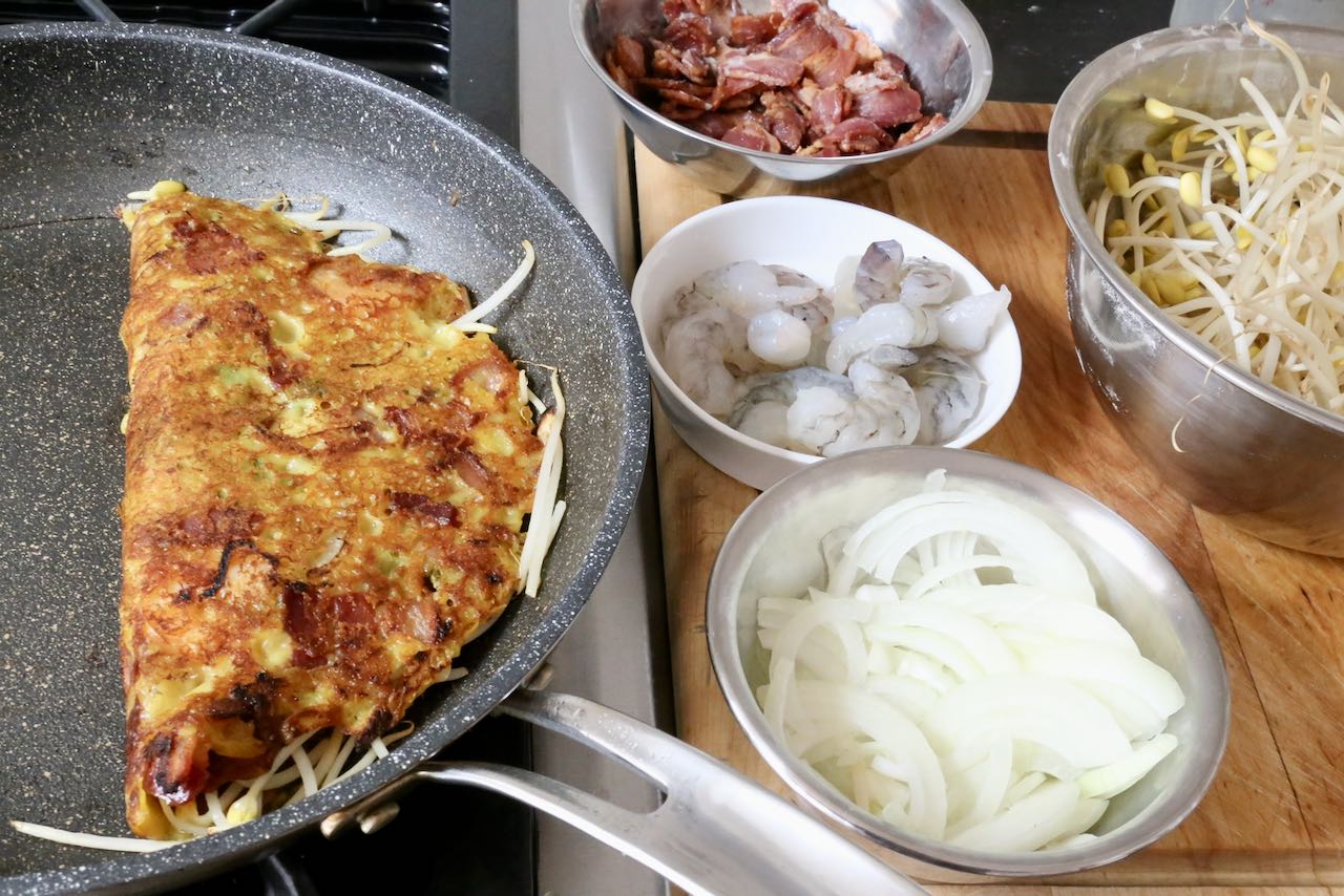 Vietnamese Crepe Step 4: Remove lid and sizzle for 3 minutes before flipping into a half moon shape.