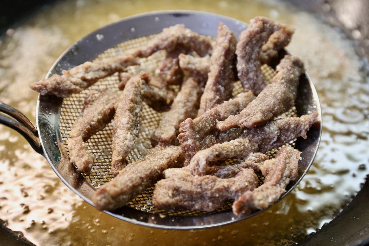 Calgary Ginger Beef: Fry flank steak in hot oil until crispy, golden brown.