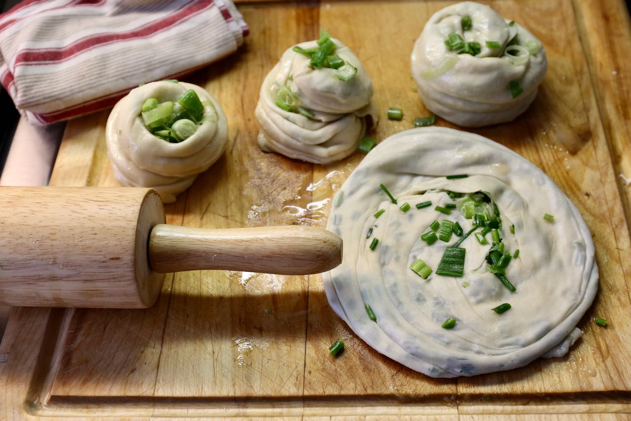 A few minutes before cooking, flatten each Cong You Bing with your hand and rolling pin.