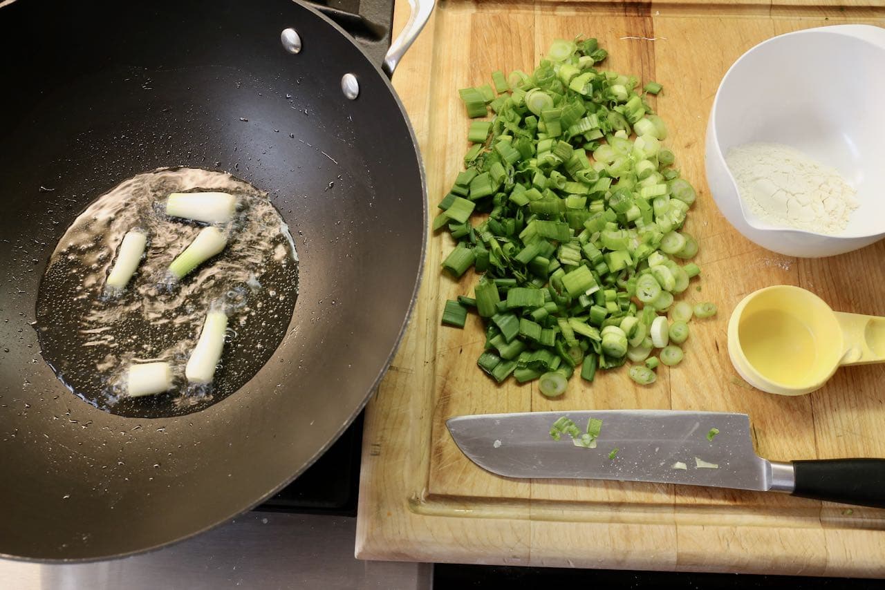Fry Green Onion whites in oil to flavour the interior of the dough.