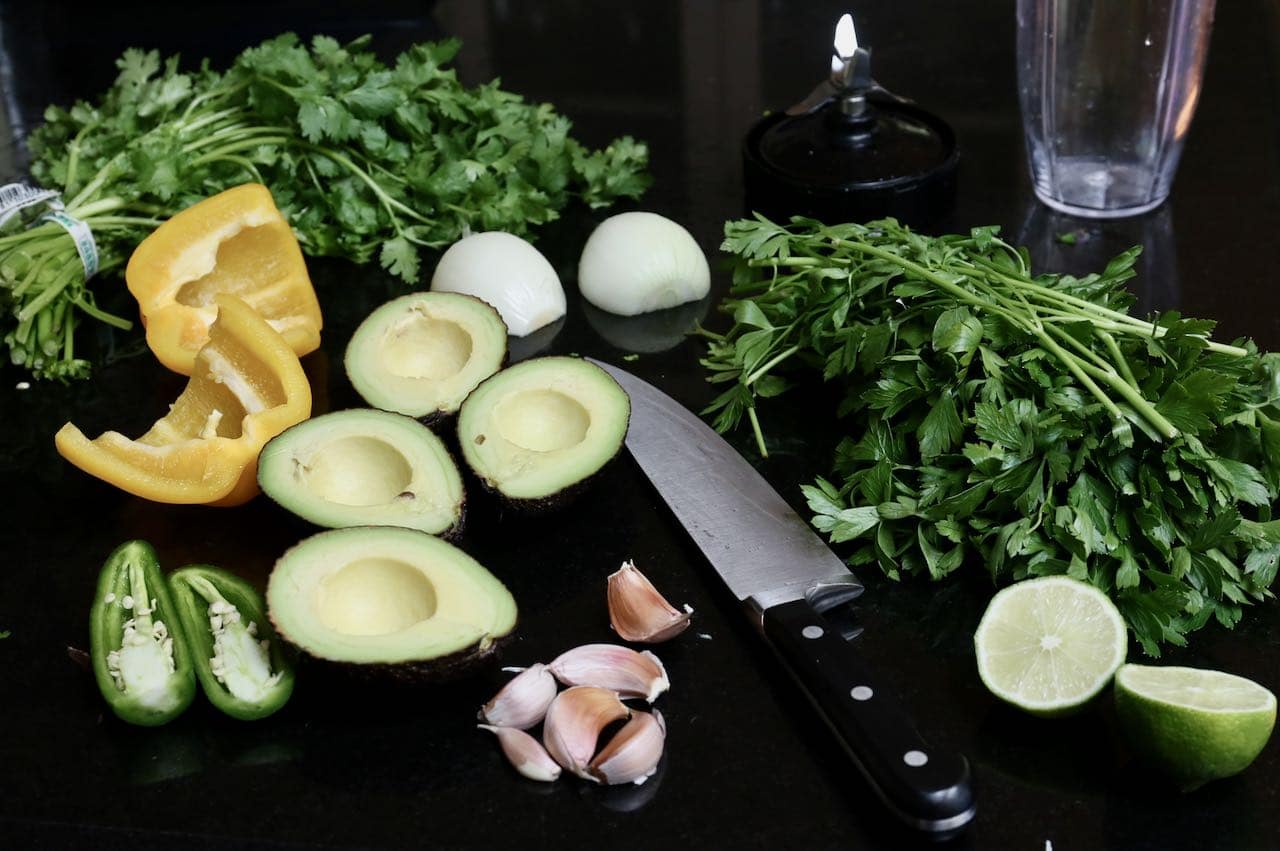 Prepare Guasacaca ingredients by chopping into small pieces and placing in a food processor.