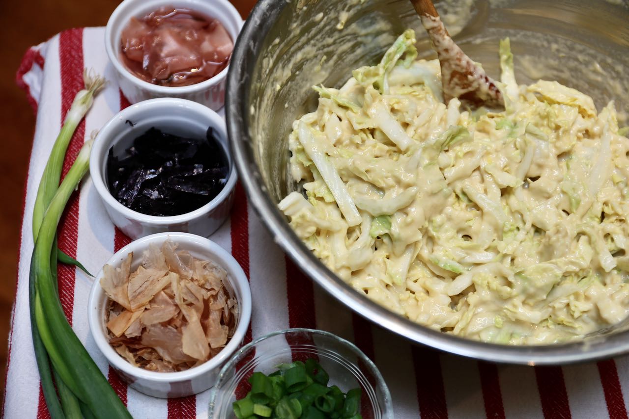 Top Japanese Cabbage Pancake with pickled ginger, nori, bonito flakes and scallions.