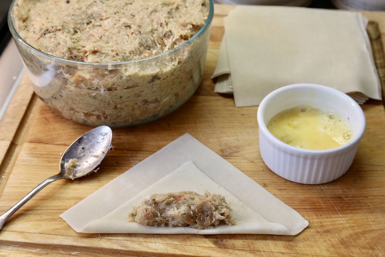 Fold & wrap Vietnamese egg rolls with the help of a small spoon and lightly beaten egg.