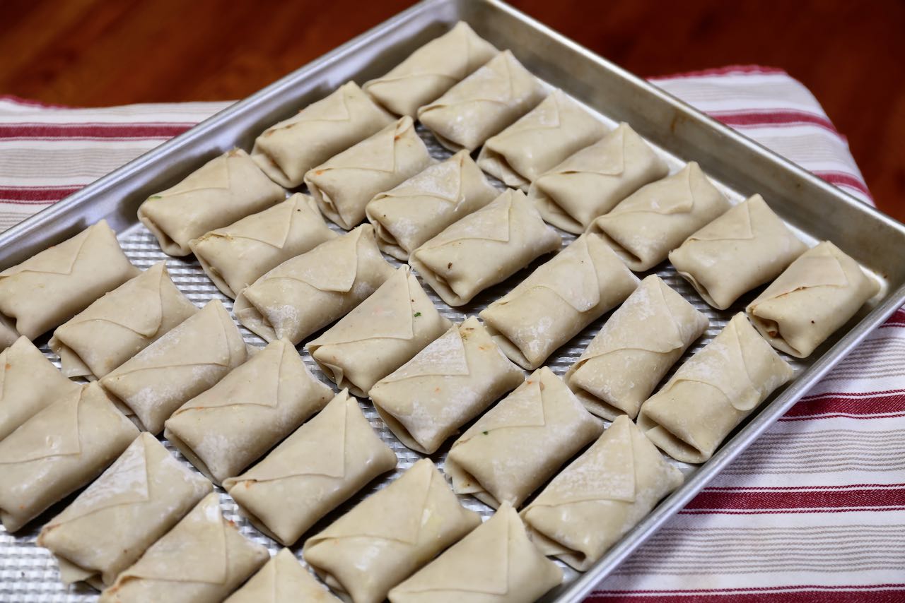 Place folded and wrapped Vietnamese egg rolls on a baking sheet.