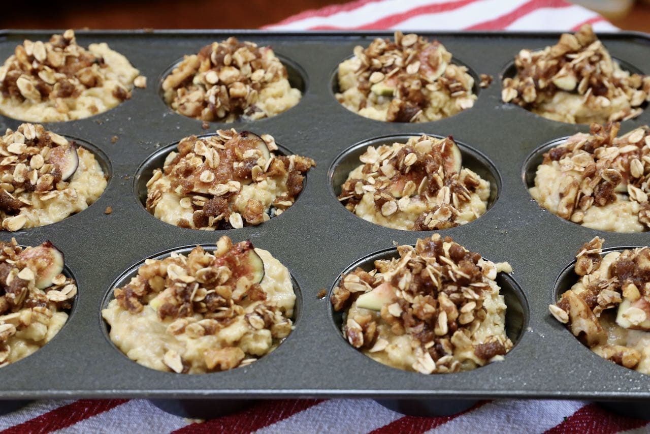 Top muffins with oat crumble before baking in the oven.