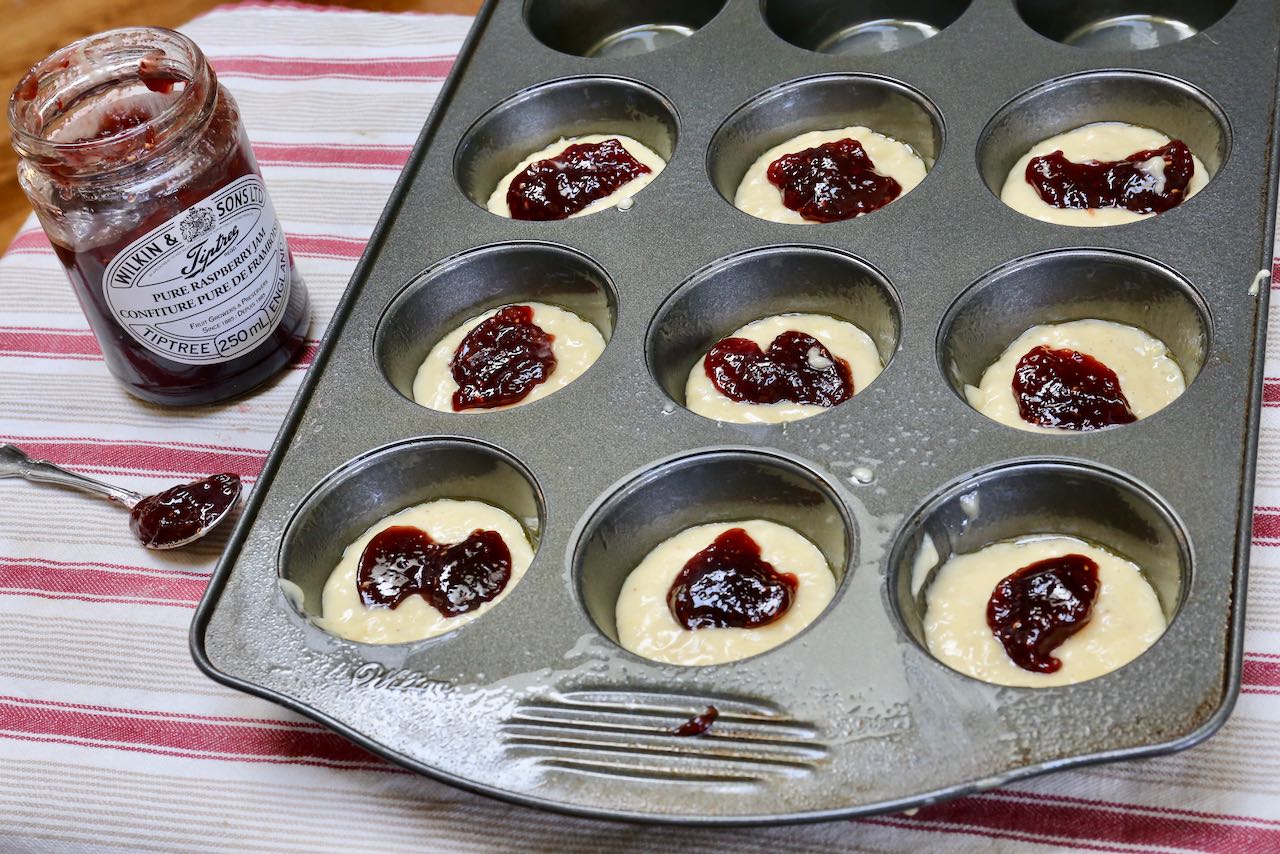 Scoop a teaspoon of jam over Old Fashioned Donut Muffin batter.