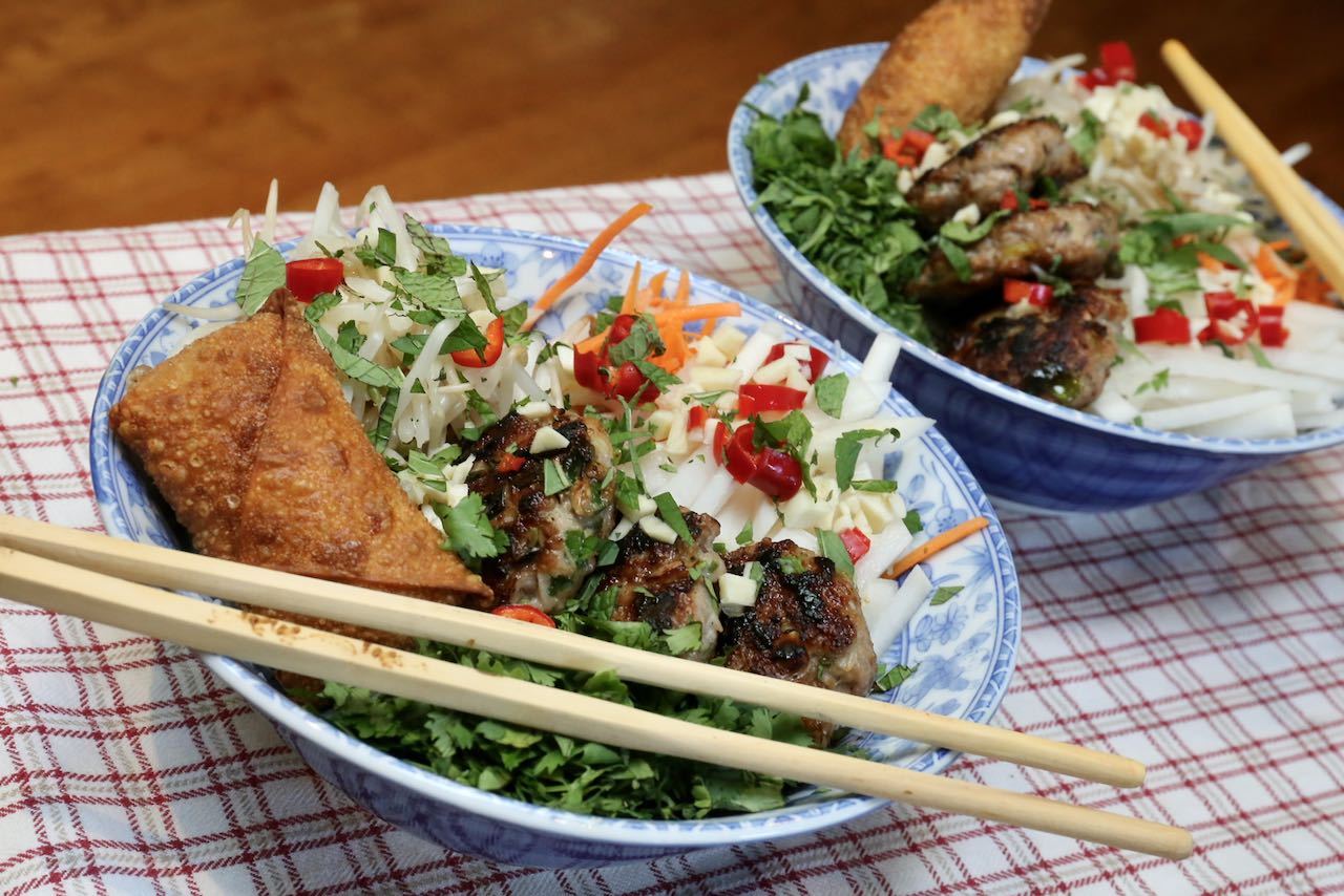 Top Bun Cha rice noodle bowls with chopped fresh herbs.