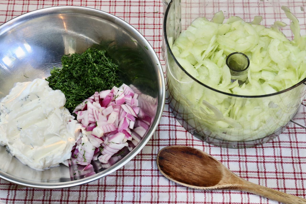 Slice cucumber in a food processor. Combine salad ingredients in a mixing bowl.