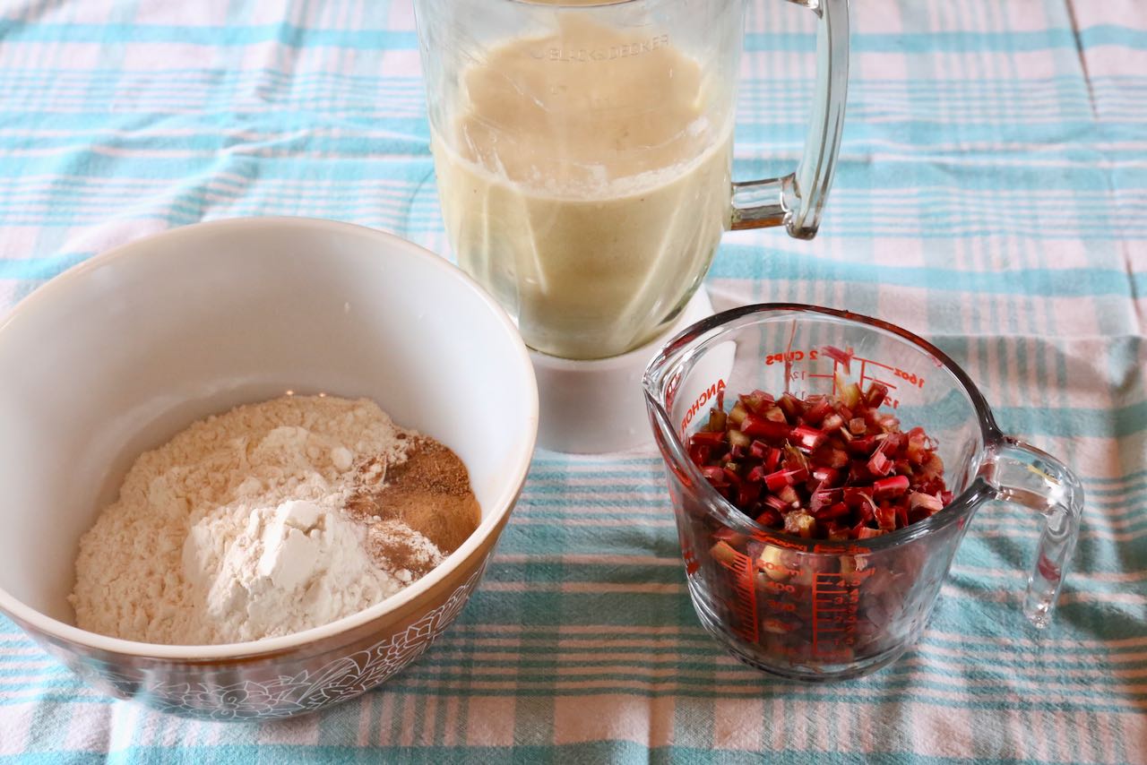 Sift dry ingredients in a mixing bowl,  blend wet ingredients in a blender, measuring chopped rhubarb in a measuring cup.