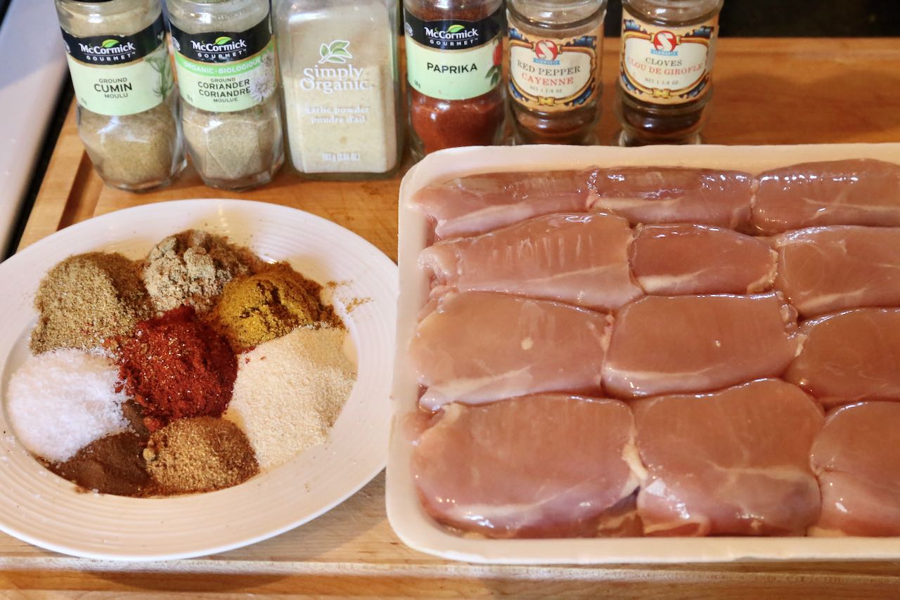 Measure shawarma spices and slice chicken thigh meat. 