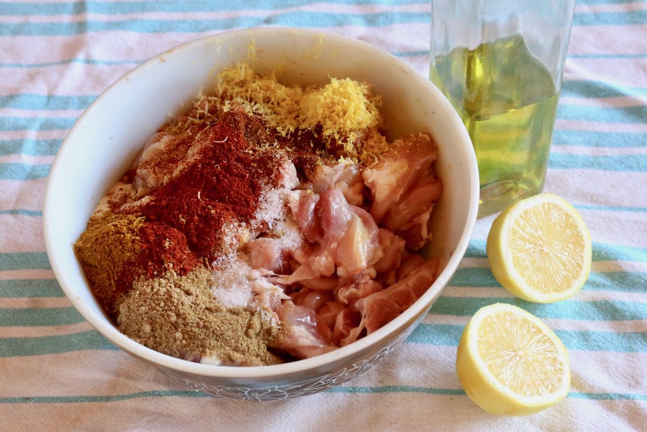 In a mixing bowl toss sliced chicken with spices, lemon and olive oil before marinating in the fridge.