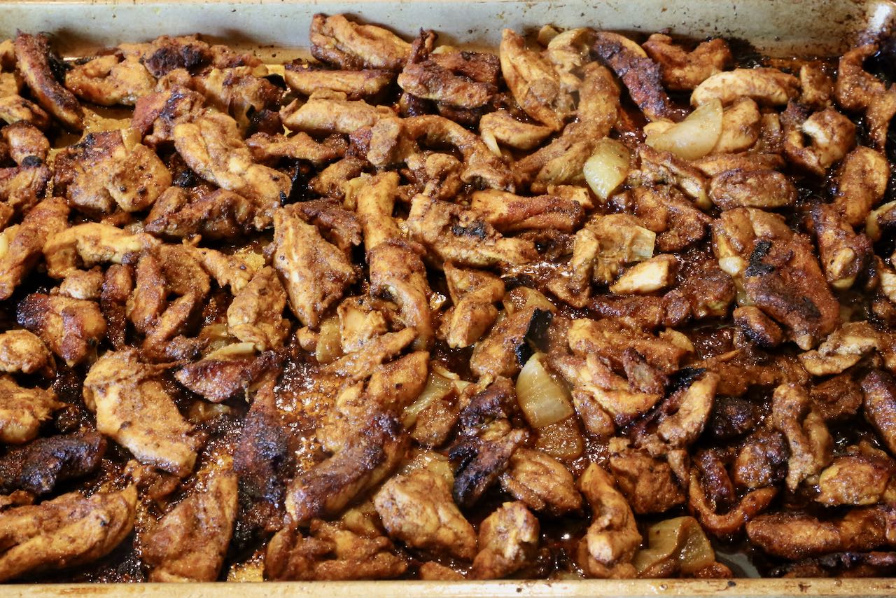 Roast chicken shawarma in the oven on a baking sheet.