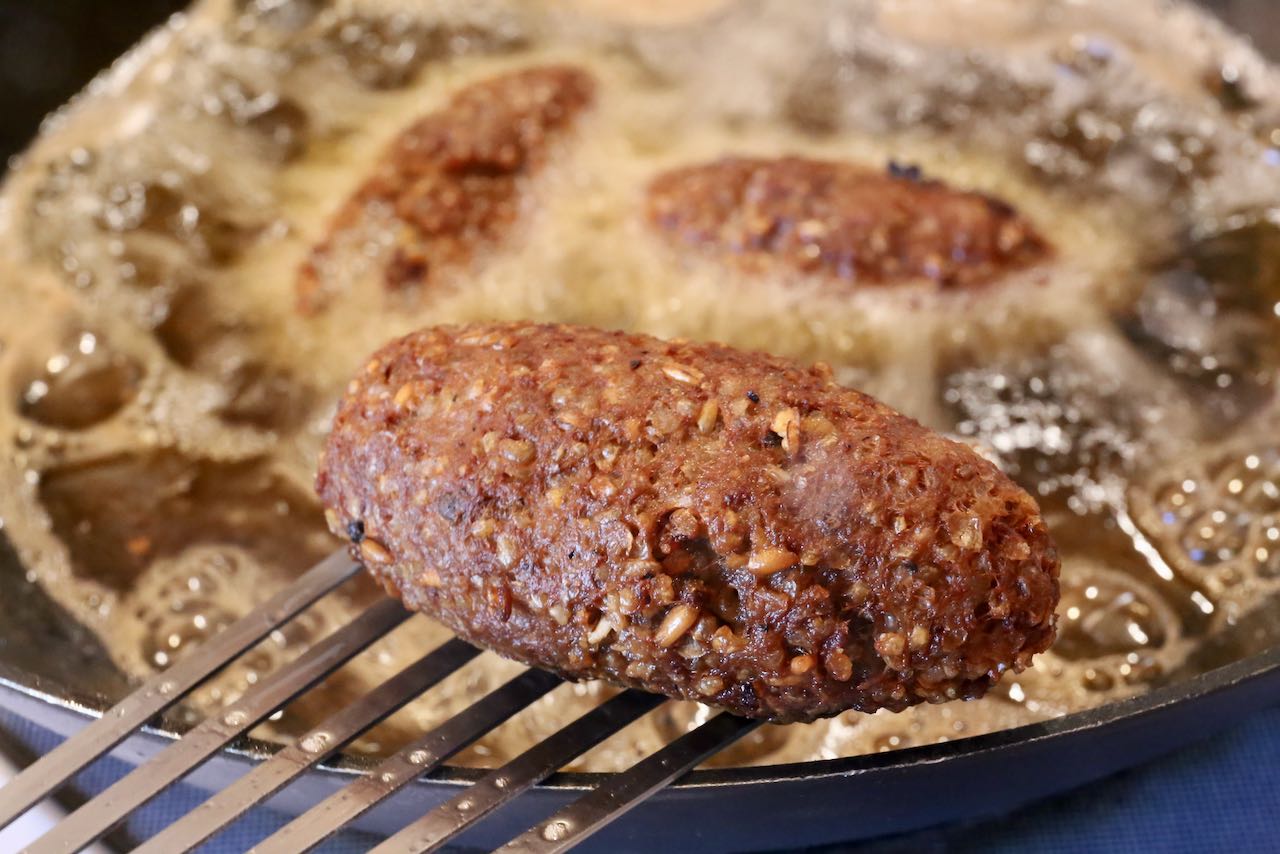Remove fried kibbeh from bubbling oil using metal tongs or flipper.