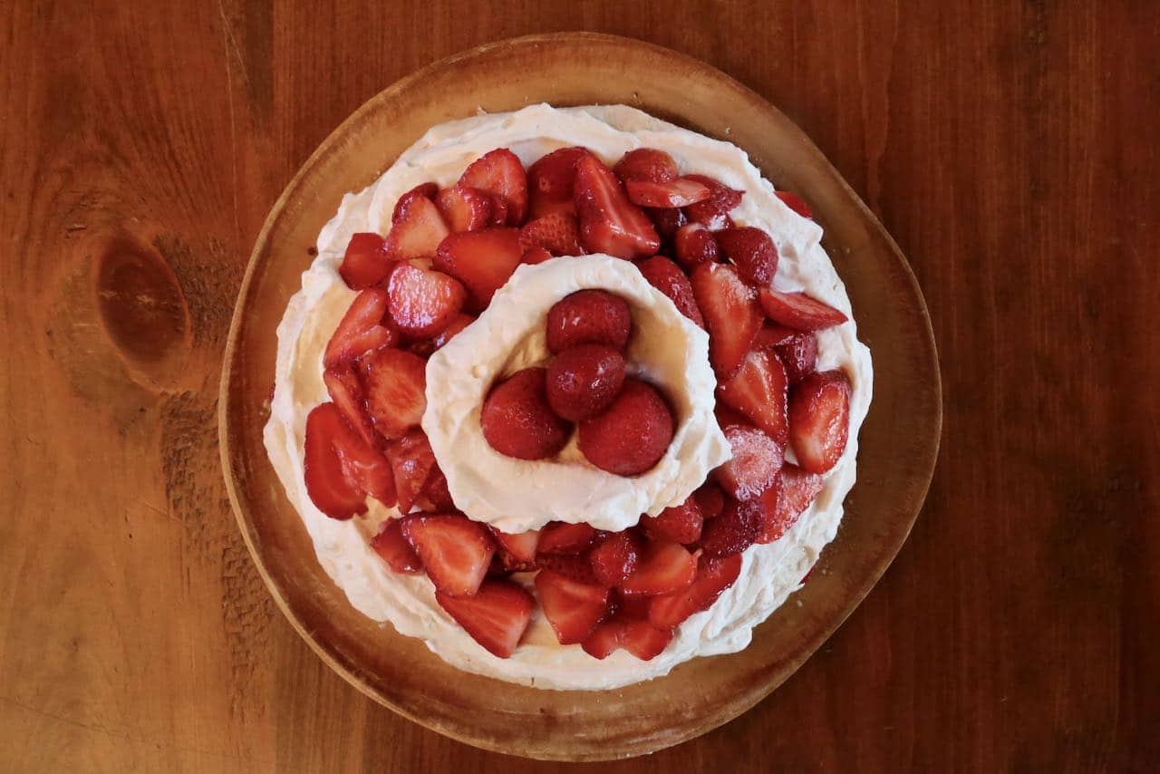 Top homemade Jordgubbstårta with a dollop of whipped cream and strawberries