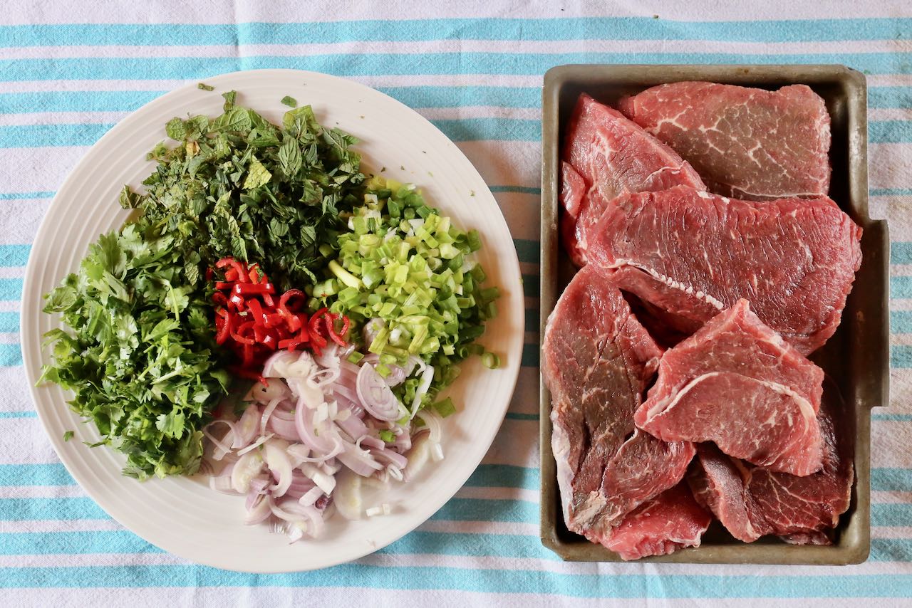 Nam Tok is a Thai Beef Salad featuring steak, mint, cilantro, scallion, shallot and spicy red chili.