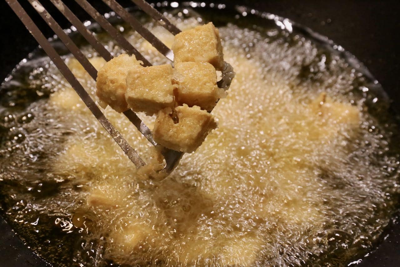 Deep fry firm tofu cubes after tossing them in cornstarch.