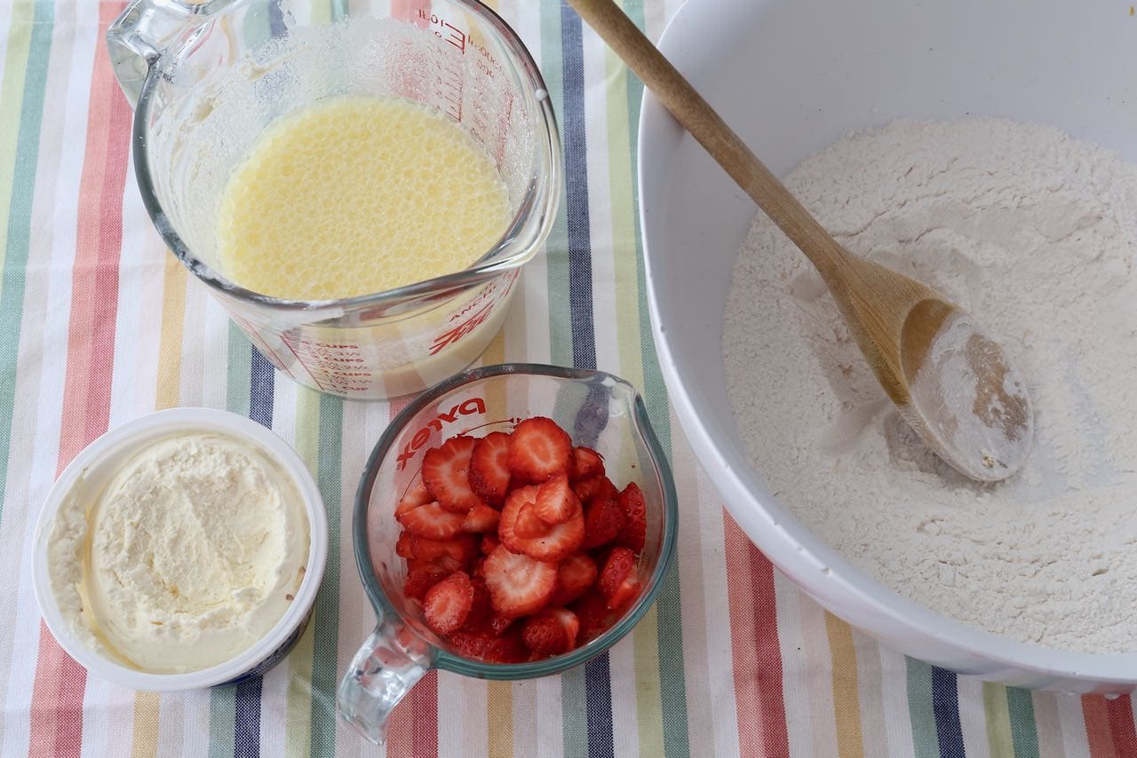 Slice strawberries, beat together wet ingredients and sift dry ingredients in a mixing bowl.