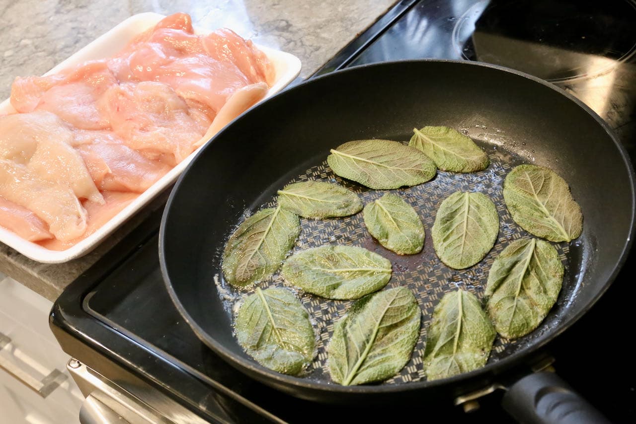 Begin preparing Involtini di Pollo by frying sage in butter until crispy.