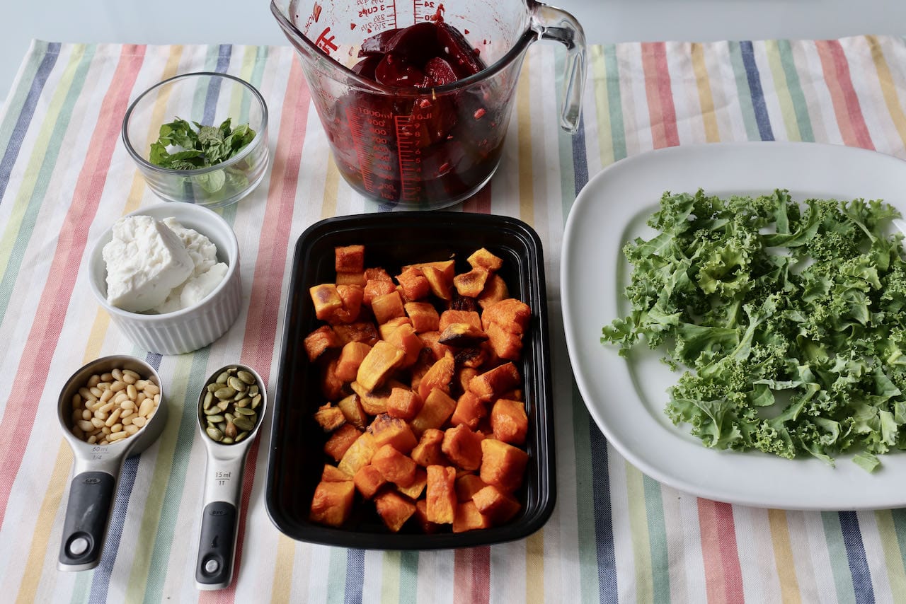 Assemble Pumpkin Pine Nut Salad by adding a layer of chopped kale to a large plate or shallow bowl.