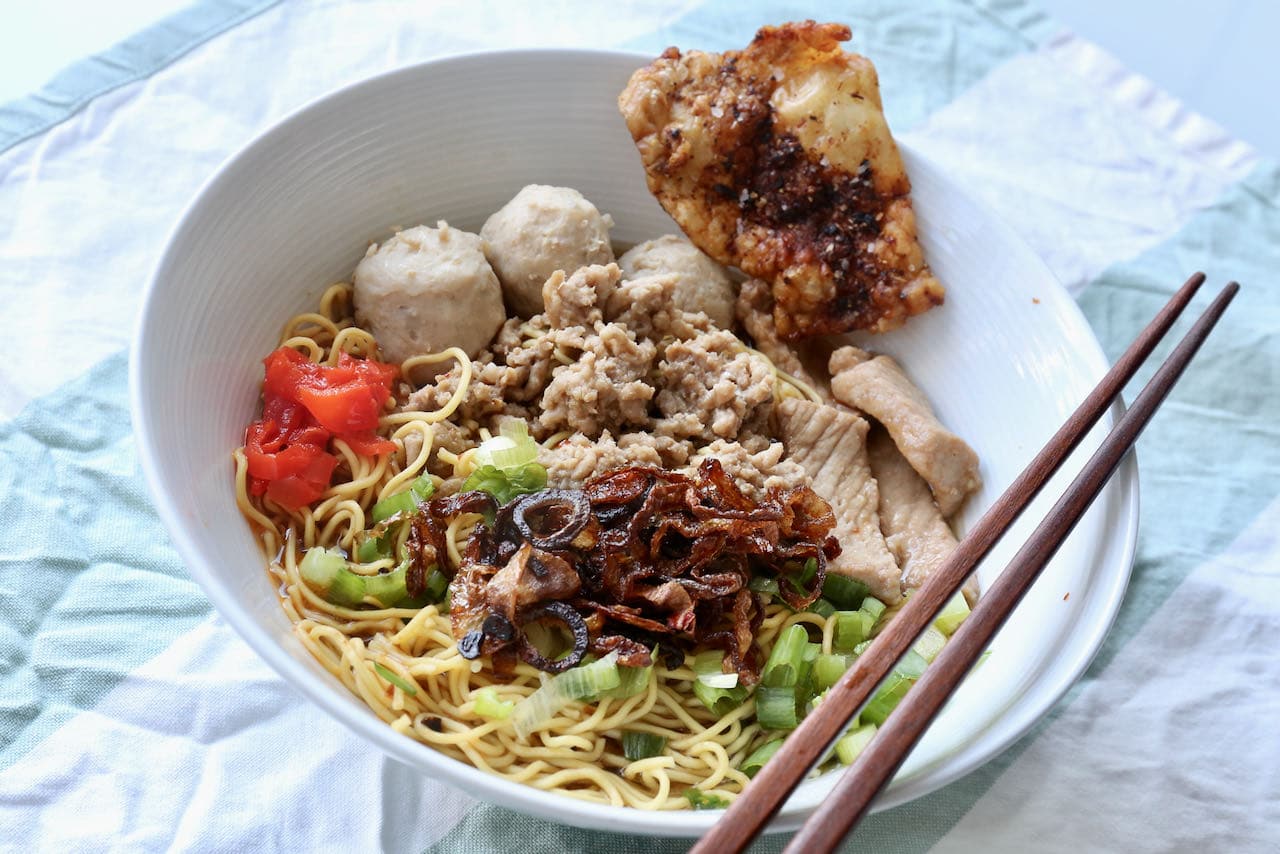 Bak Chor Mee features noodles tossed in a spicy sauce. The bowl is then filled with chicken broth. 