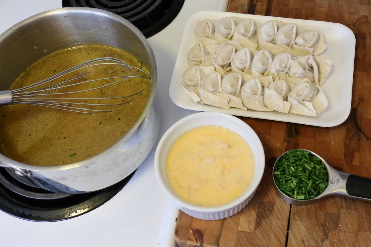 Add frozen wontons to hot chicken broth then slowly add scrambled egg.