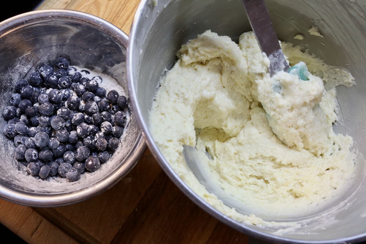 Add fresh blueberries to the creamy muffin top batter and gently fold the fruit into the mixture until well combined.
