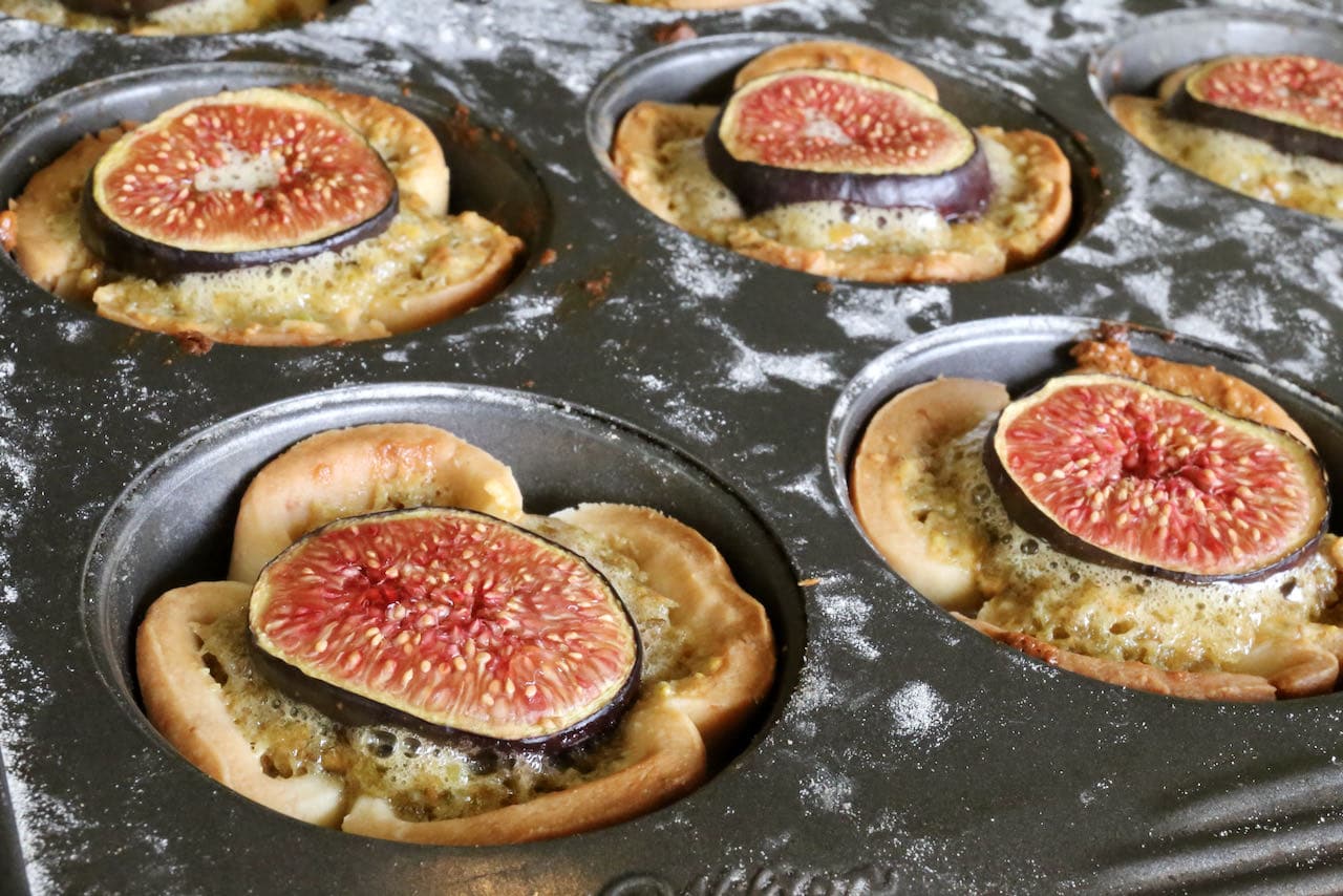 Top Pistachio Tartlets with slices of fresh fig.