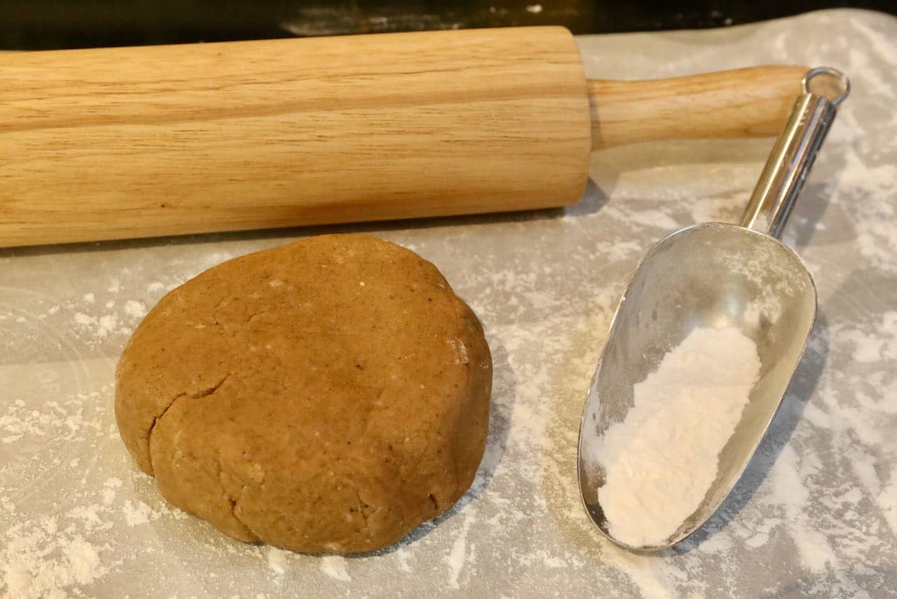 Roll chilled Gevulde Speculaas dough onto a lightly floured surface with a rolling pin.