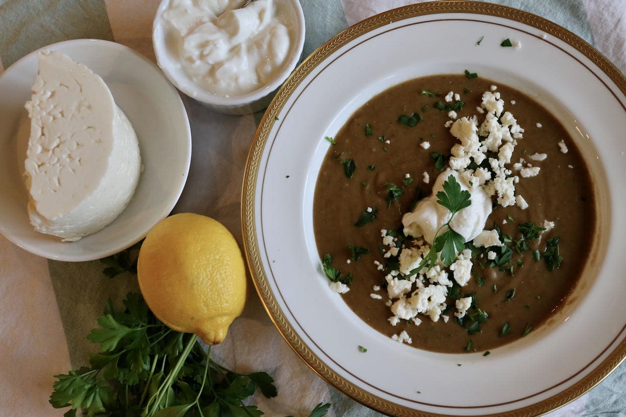 Garnish purred Fakes Soupa with Greek yogurt, parsley and crumbled feta cheese.