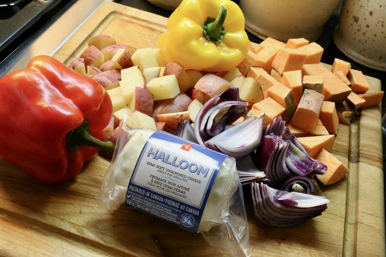 This healthy baked halloumi recipe features red onion, bell peppers, potatoes and sweet potatoes.