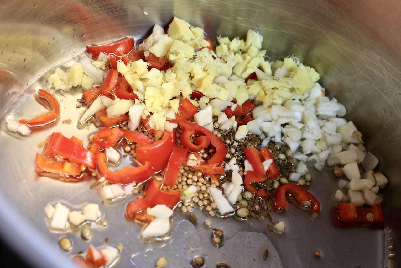 In a large pot saute garlic, ginger, chili and spices until fragrant.
