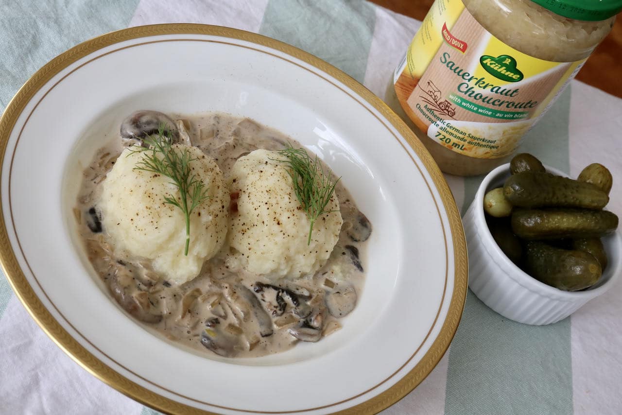 Serve Kartoffelknödel with dill pickles and sauerkraut.