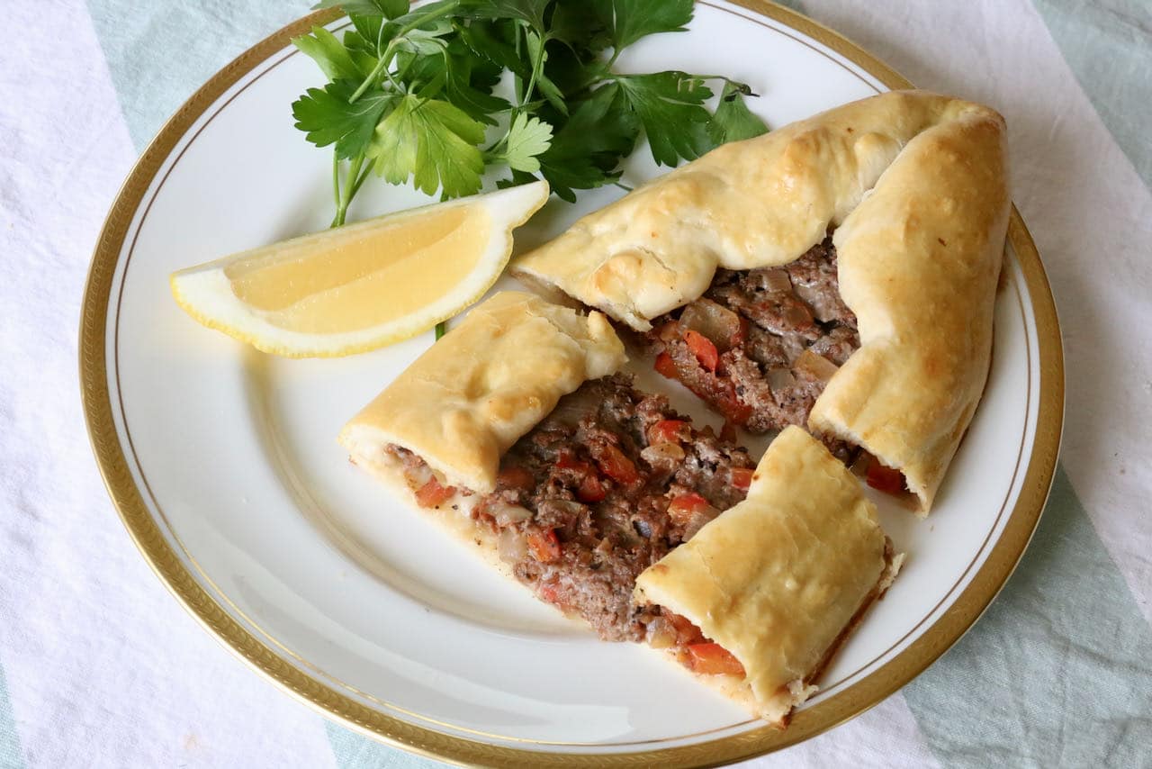Serve Kiymali Pide with lemon wedge and fresh parsley.