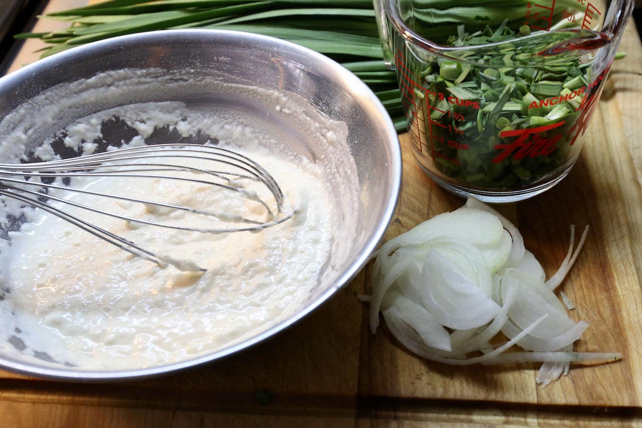 Prepare the Chive Pancakes batter in a mixing bowl and slice the vegetables.