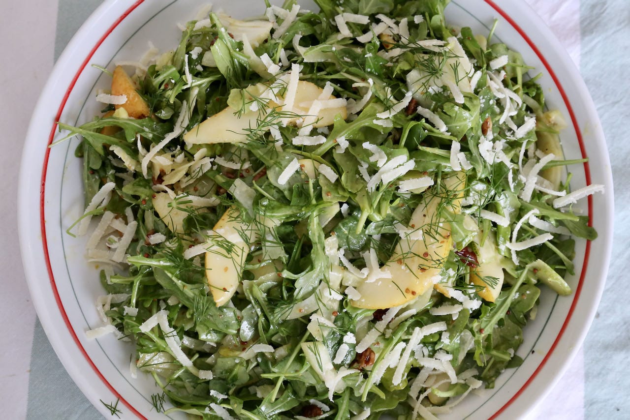 Serve Rocket Pear Salad garnished with chopped dill and grated parmesan cheese.