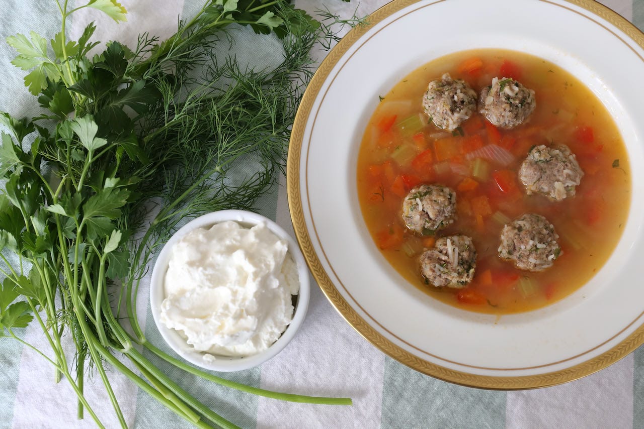 Serve Romanian Soup with sour cream, dill and parsley.