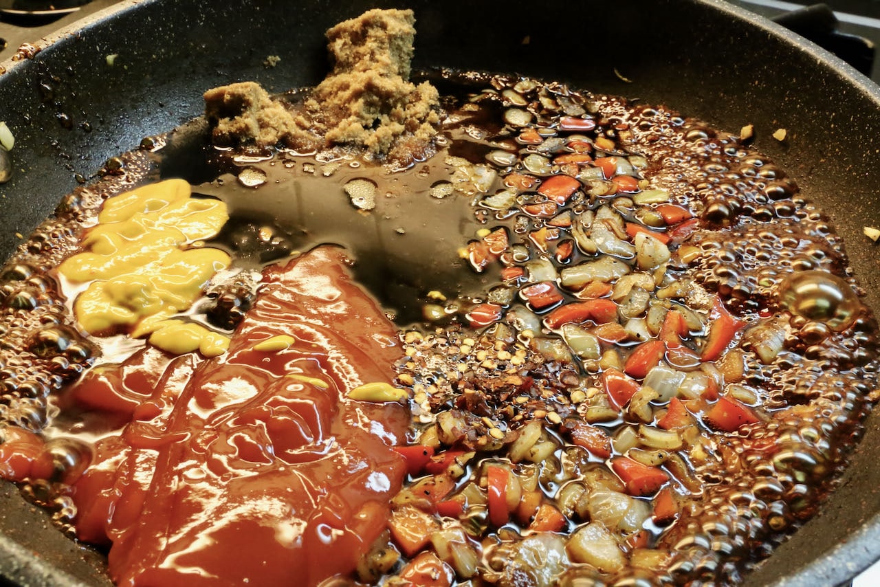 Smoked Baked Beans are flavoured with ketchup, yellow mustard, apple cider vinegar, molasses, and red pepper flakes. 