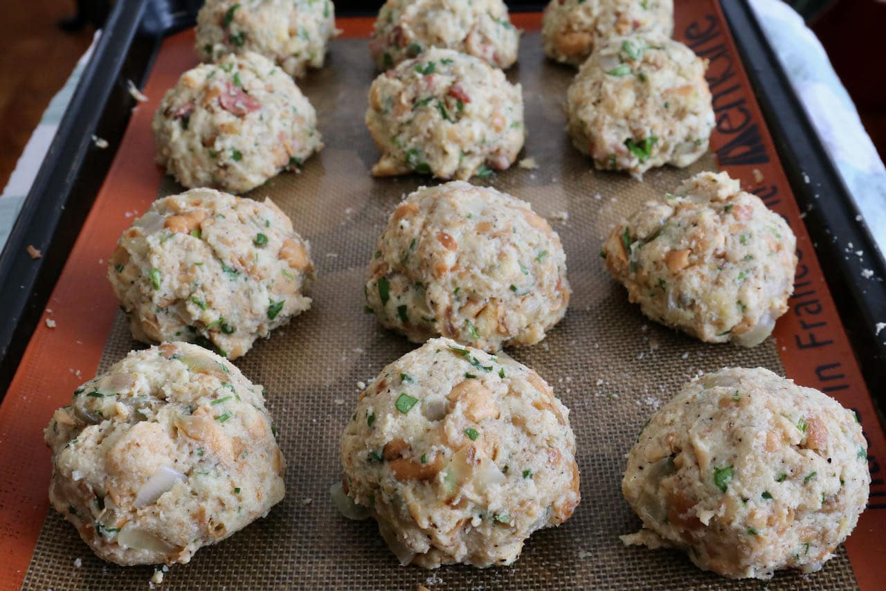 Let Speckknödel German Bread Dumplings rest on a baking sheet before boiling.