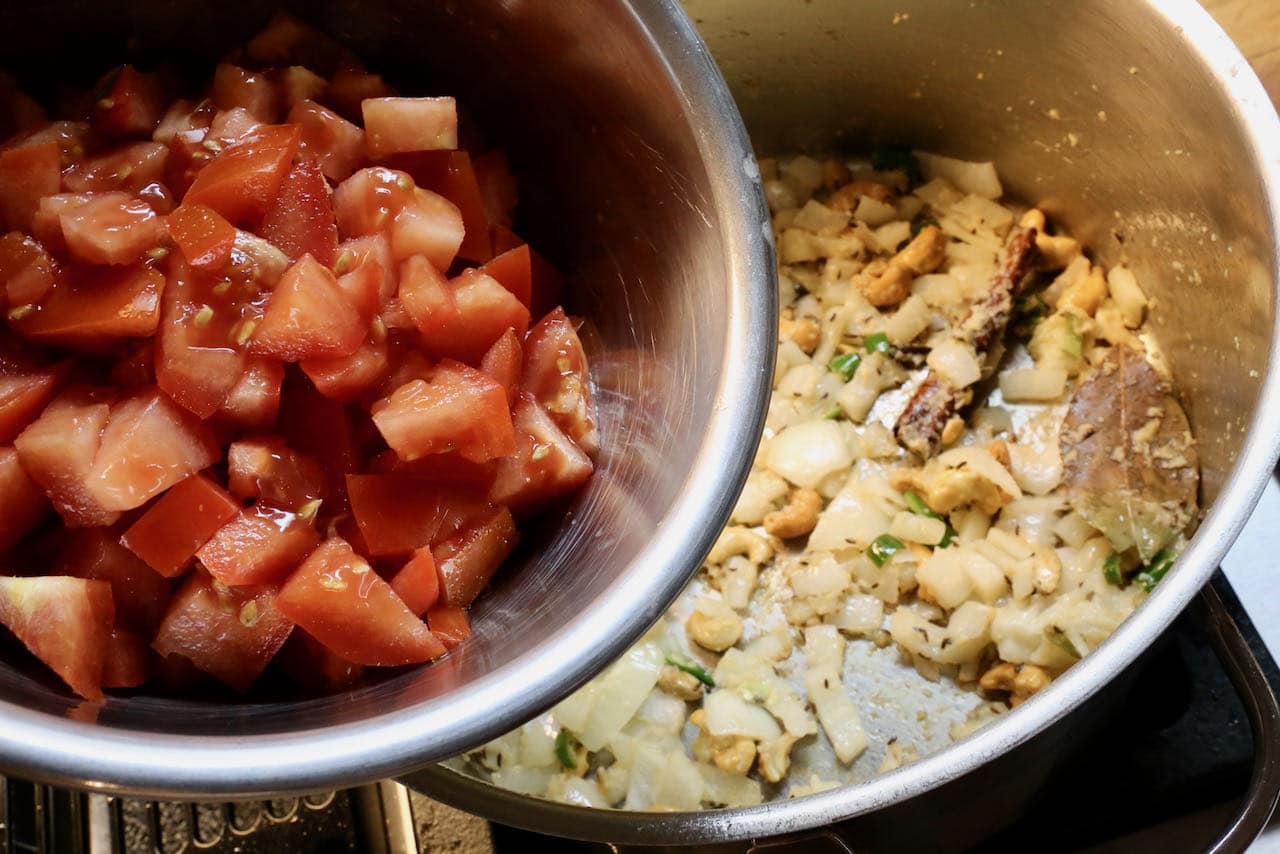 Saute vegetables, spices and cashew nuts in a large pot then add diced tomatoes.