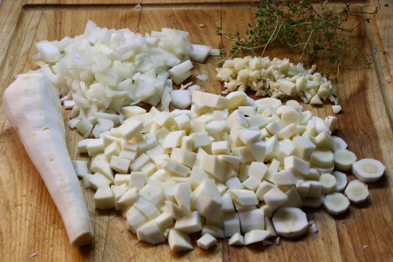 Begin by chopping parsnip and onion and remove thyme leaves from their sprigs.