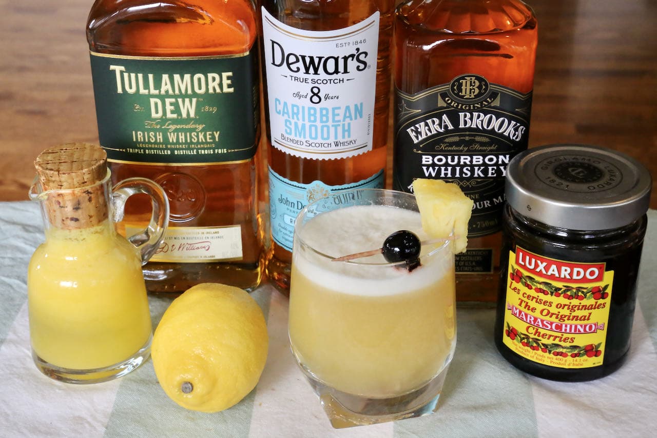 Our Pineapple Sour drink is garnished with fresh pineapple and a Maraschino cherry.