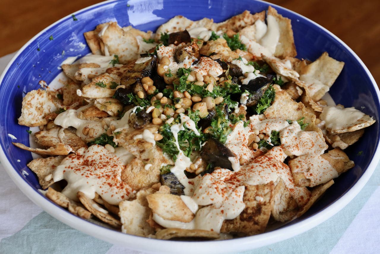 Serve Eggplant Fatteh immediately as the crunchy pita pieces get soft and soggy quickly.