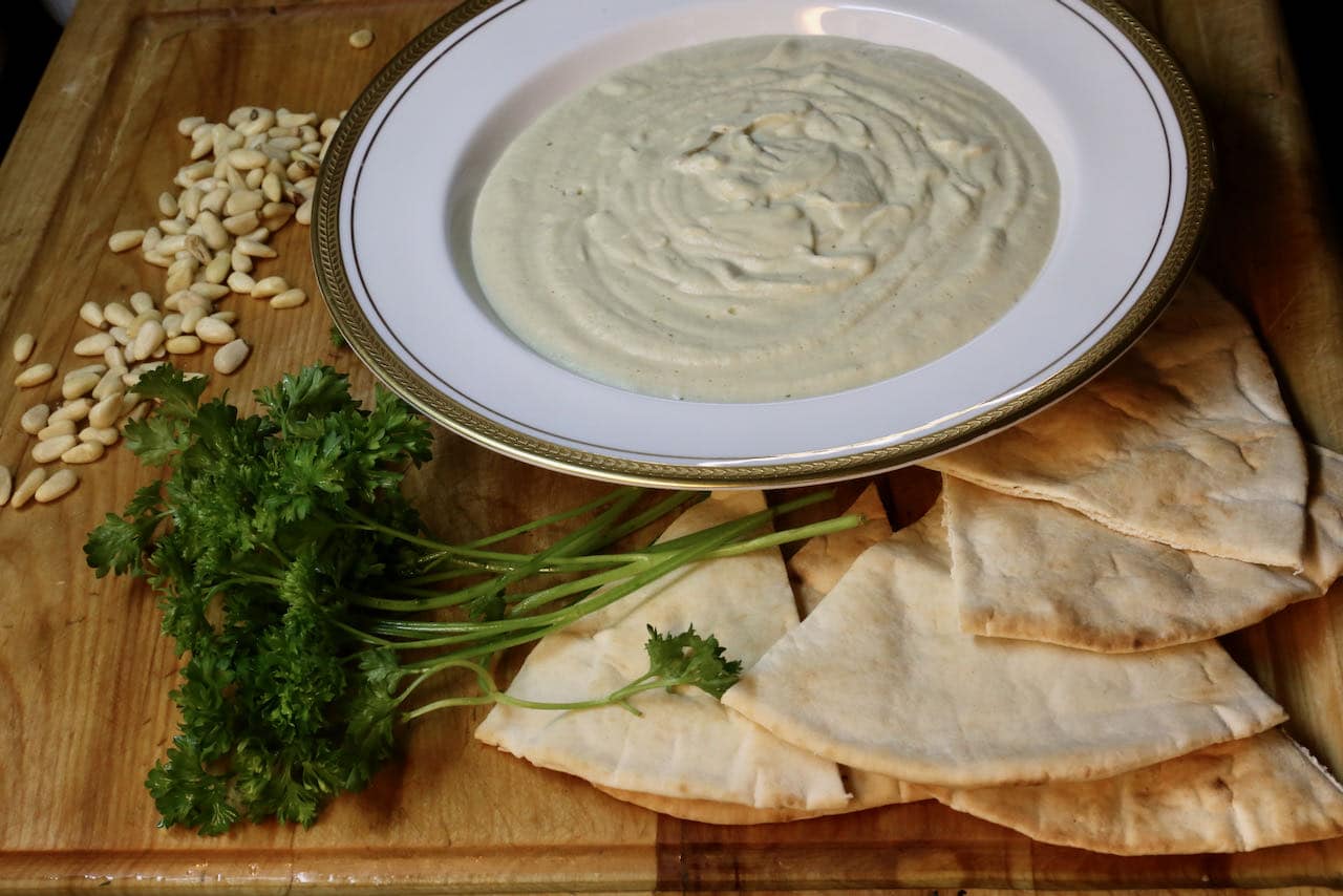 Serve this vegan Mutabbal recipe topped with parsley, pine nuts and pita bread.